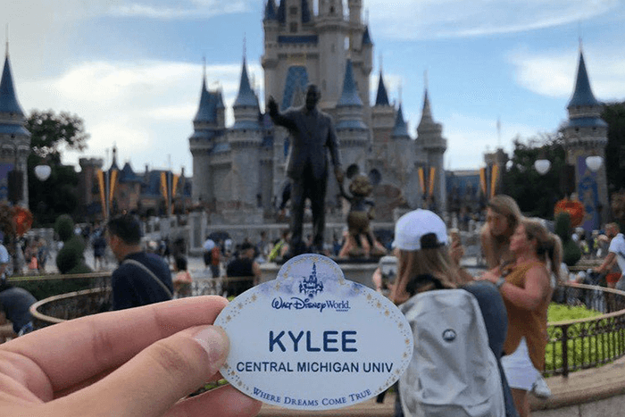 CMU Student Kylee holding her name badge 700 x 467 girl holder her Disney name badge in front of Disney castle