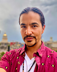 Image of TyDefoe wearing a red collared shirt over a white shirt.