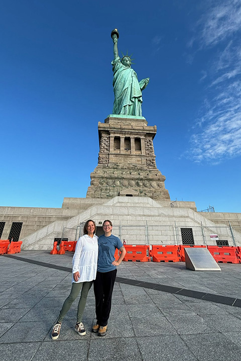 CMU alums Fern Borus and mother Patti Borus stand together in front of the Statue of Liberty.