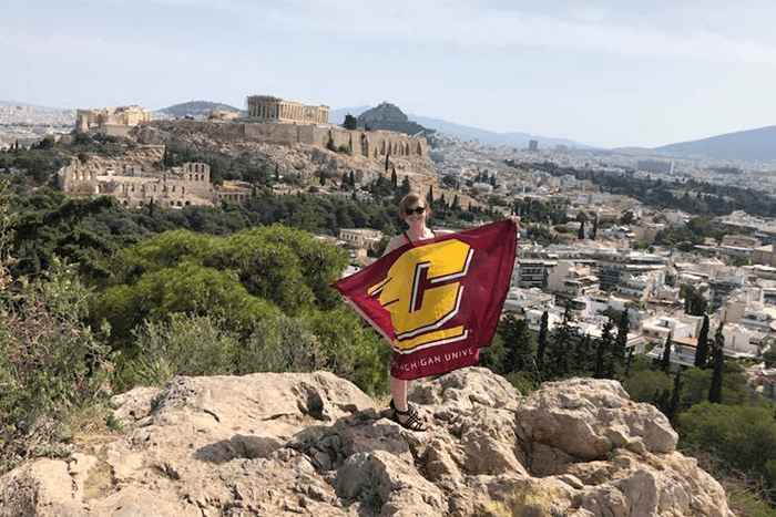 Student holding a CMU flag near the Parthenon