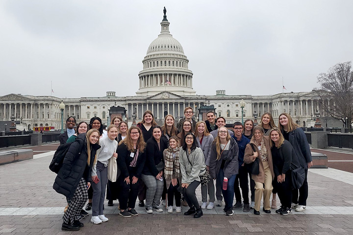 A group of Central Michigan University students and faculty member Emma Powell stand in front of the U.S. Capitol Building in Washington D.C.