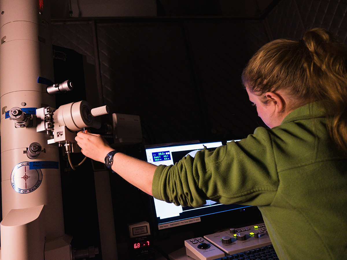 A student adjusting settings on a large bioimaging microscope.