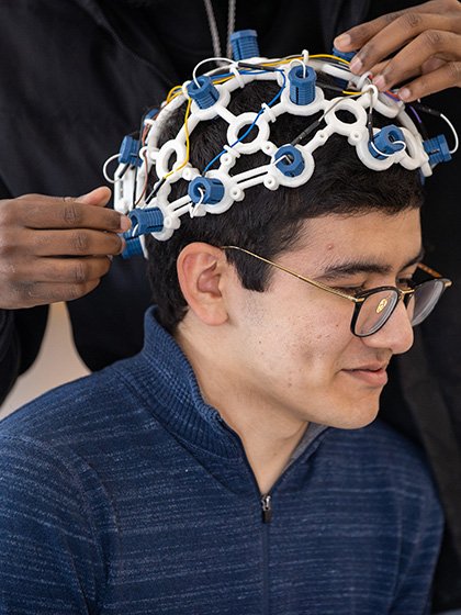 A student wearing a brain computer interface helmet.
