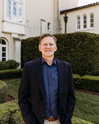 A man in a suit standing in front of a building.