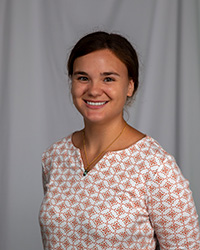 20250904_Anna Lubbers_200x250 a woman with dark hair and a patterned blouse smiling at camera