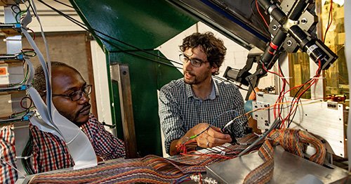 Alfredo Estrade and a graduate student preparing equipment for nuclear physics experiments.