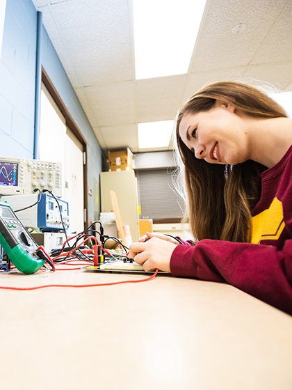 Engineering student Julia Reynolds adjusts equipment in the Electronic Engineering Lab.