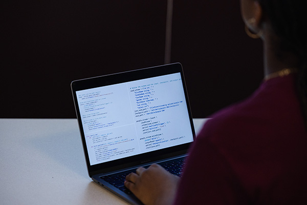 A person typing on a laptop that is displaying data.