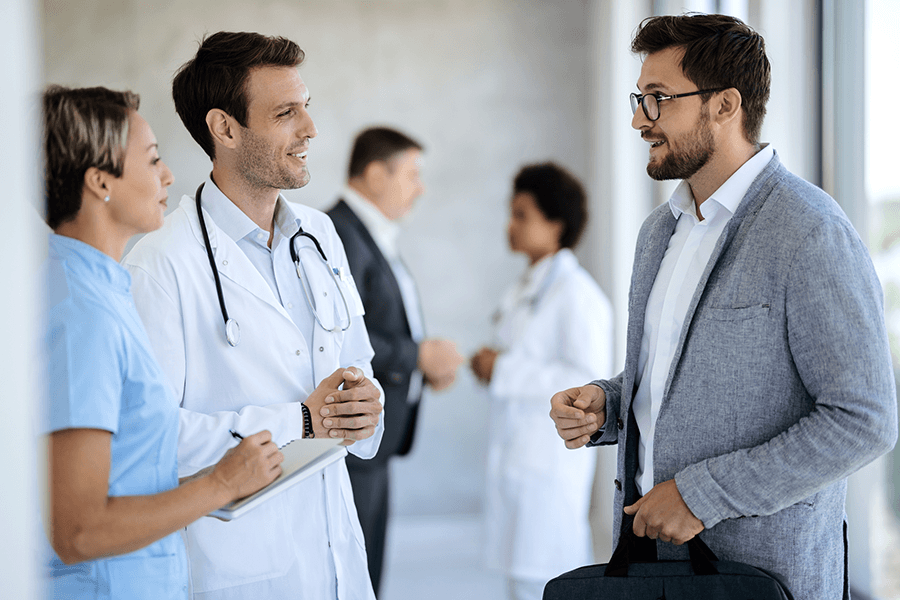 Hospital administrator speaks with a doctor and a nurse.
