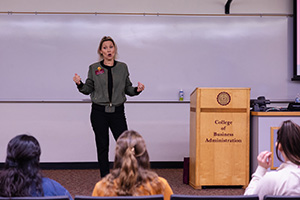 A female presenter speaks to an auditorium full of first generation students at CMU.