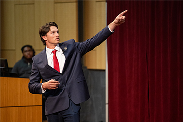 A man in a suit pointing his finger.
