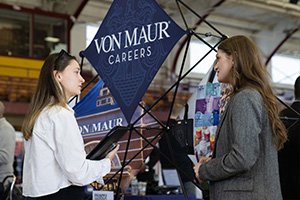 Students at a career fair on campus connecting with potential employers.