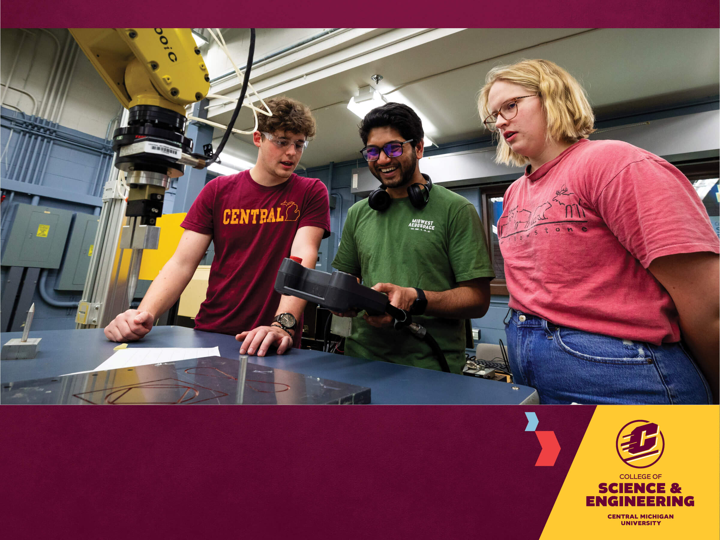 students working in engineering lab controlling a mechanical arm