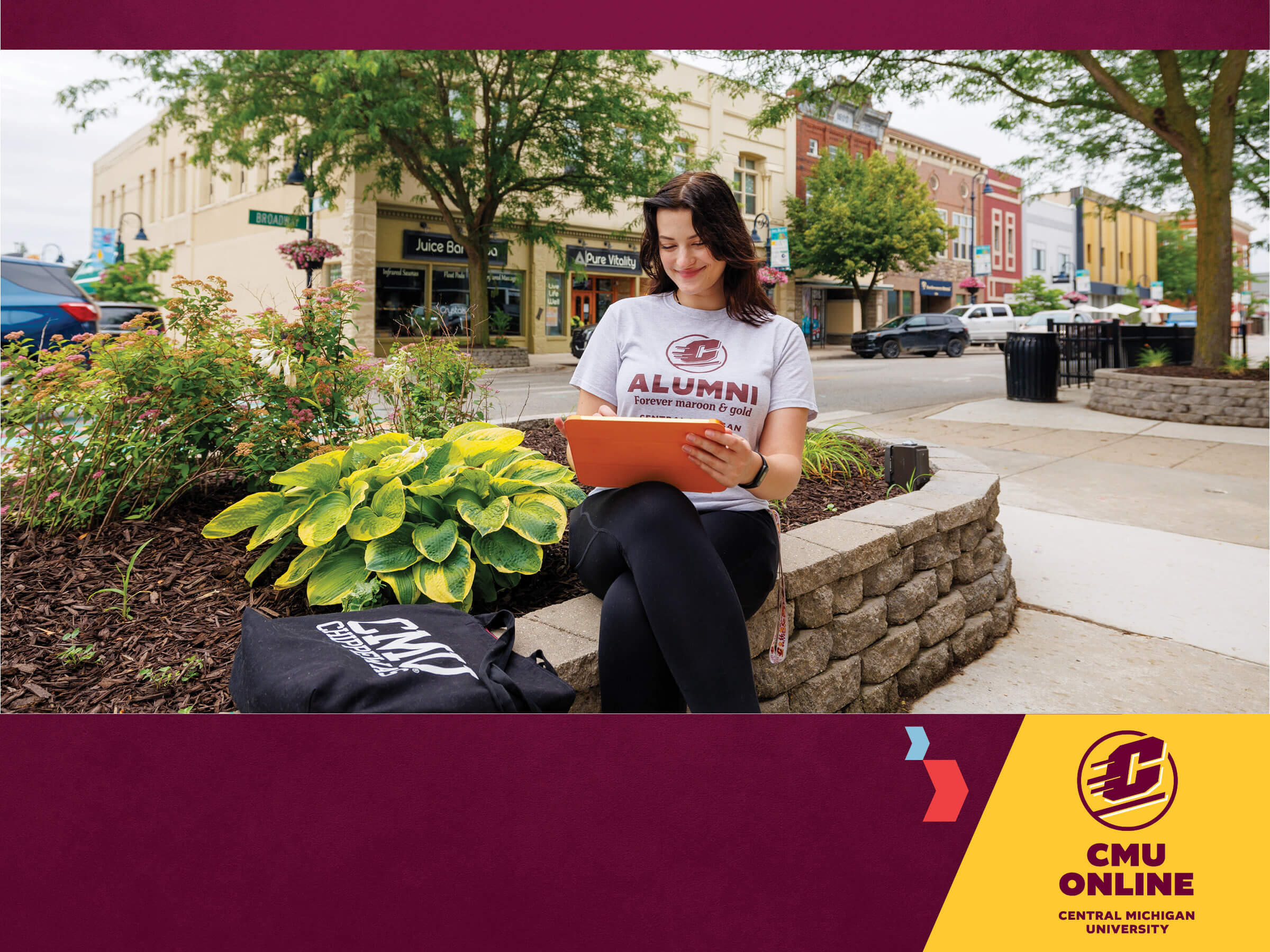 Student sitting in down town mount Pleasant working on a tablet