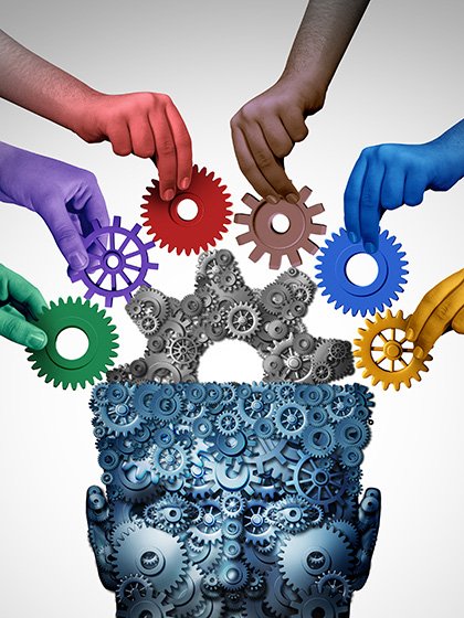 Hands of different colors (green, purple, red, brown, blue, and yellow) hold cogged wheels up to a large dark gray cogged wheel extending from the open top of a head constructed of blueish cogged wheels with a light gray background.