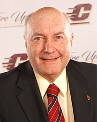 Philip Kintzele wearing a suit coat, white collared shirt and red tie while looking at the camera.