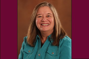 CMU's Betty Wagner wearing a turquoise top and smiling into the camera.