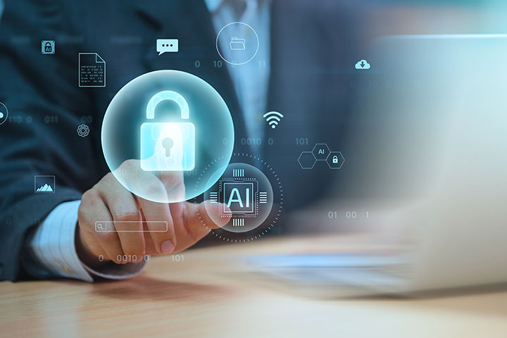 Two circles, one containing the letters AI and another containing a locked padlock, float in the air in front of a background of a man in a suit sitting at a laptop computer.