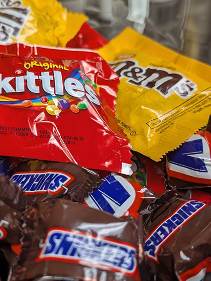 Small packages of various candy piled together.
