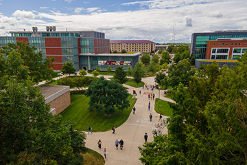An aerial view of people walking on sidewalks through a college campus