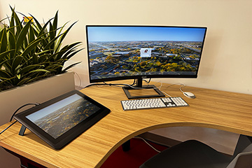 A computer screen and keyboard on a desk