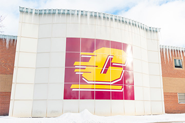 A building with a "C" logo on it has icicles coming down the side.
