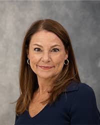 Cheryl Danner, Counselor, professional headshot picture, wearing a dark blue shirt, with a grey background