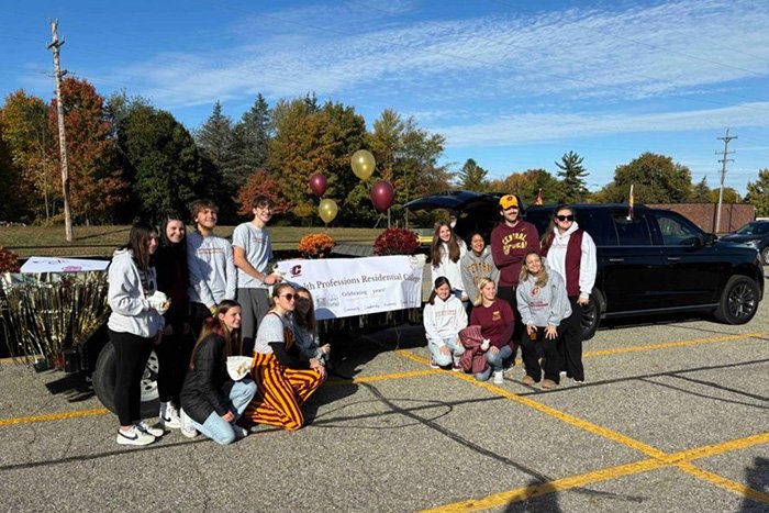 Students in front of the Homecoming float celebrating 25 years of Health Professions Residential College.