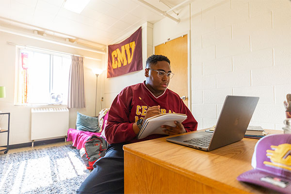 A student on their laptop in a CMU dorm room.