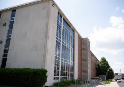 Side view of Saxe Hall featuring patterned concrete stairwell and beige entry doors.