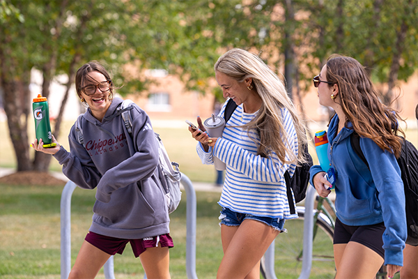 Students walking on campus while laughing.