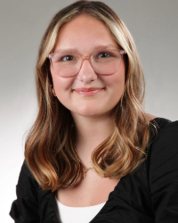 a woman wearing glasses and smiling