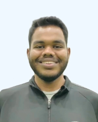 A man wearing a quarter zip sweater smiling for a picture.