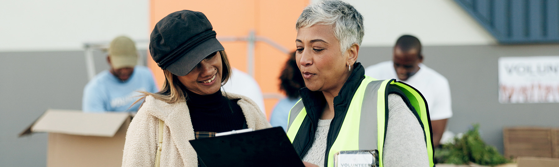 Two people at a volunteer event look over a clipboard together.