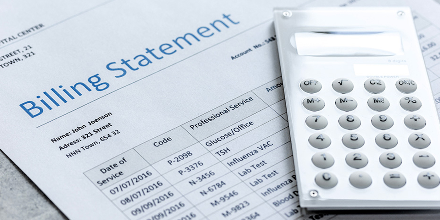 A medical billing statement paper under a calculator.