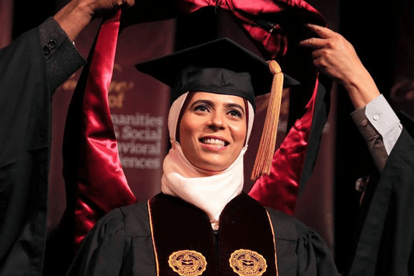 a student with a cap and gown at a commencement ceremony