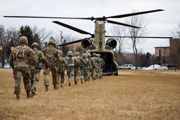Military soldiers marching to get on a military helicopter