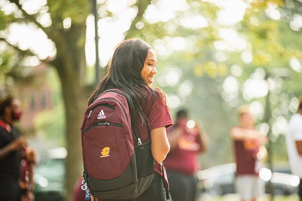 a student walking on campus with a CMU backpack on