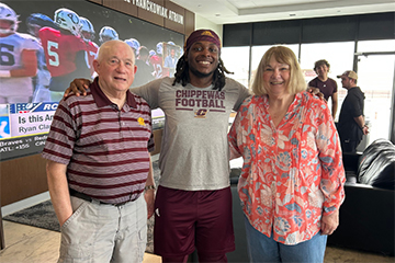 A group of three people pose for a photo.