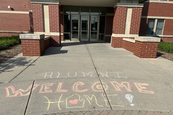 CMU residence hall entrance with Welcome Home messaging on the sidewalk.