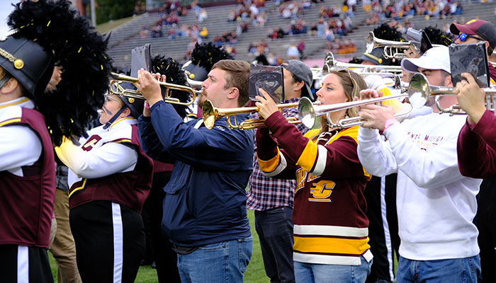 alumni_band_700x400 Central Michigan University marching band alumni play trumpets in unison during a football game halftime performance at Kelly/Shorts Stadium.