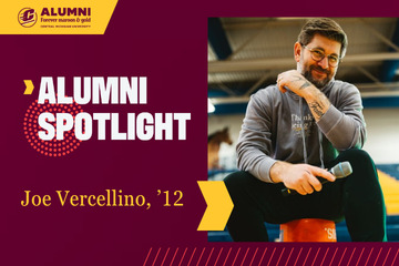 Central Michigan University Alumni Spotlight graphic featuring Joe Vercellino, class of 2012, wearing a grey hoodie and holding a microphone while sitting on an orange bucket in a gymnasium.