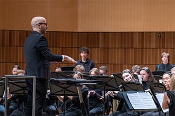A man standing in front of an orchestra.