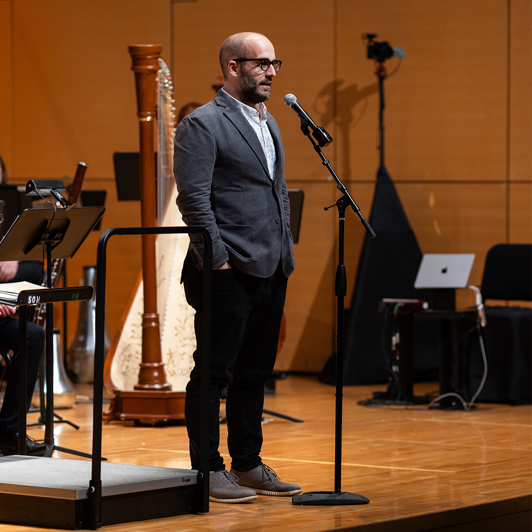 A man standing on a stage with a microphone.