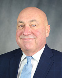 Michael Sullivan A man in a navy suit and light blue tie.
